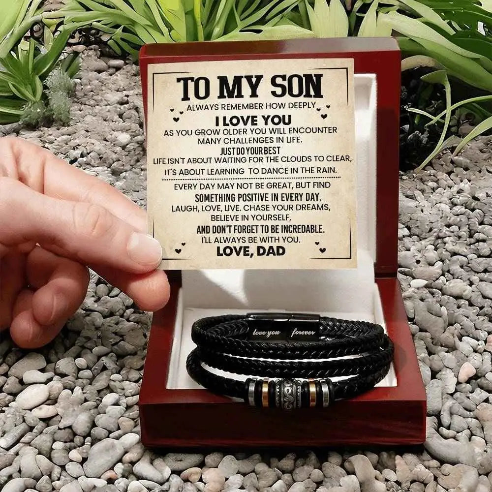 Bracelets in a wooden box with a message card on a pebbled surface