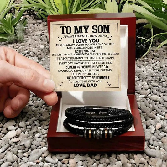 Bracelets in a wooden box with a message card on a pebbled surface