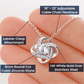 Close-up of I’m Sorry Love Knot Necklace in silver – 14k white gold over stainless steel with adjustable chain and cubic zirconia center stone.